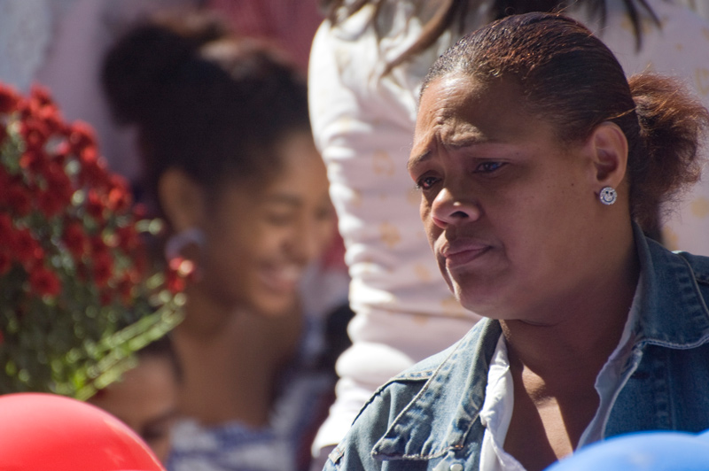 A woman listens intently to someone speaking to her.