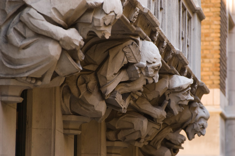 A line of four comically-carved gargoyles, making and eating chicken soup.