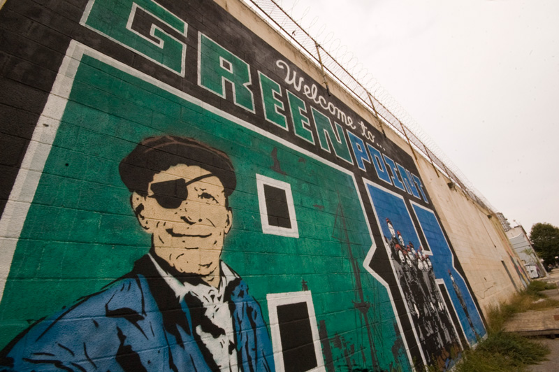 A wall mural welcoming visitors, depicting a dock worker from an earlier era.