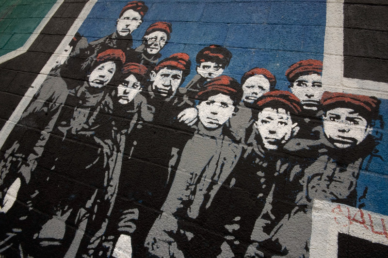 A detail from a wall mural, showing a group of poor youths from days gone by.