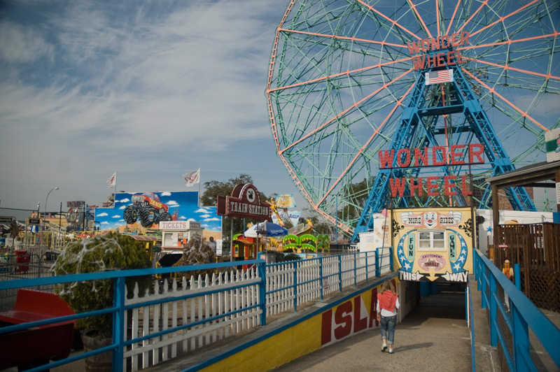 Just one person in an amuement park, walking to a ride.