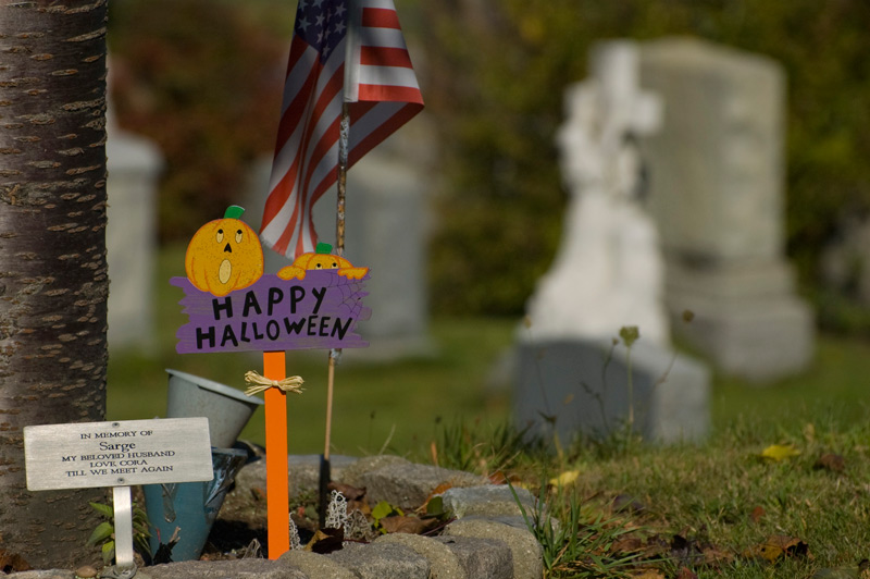 Halloween decorations next to a grave.