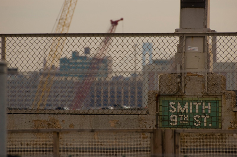 Old tiles for a subway platform, with cranes in the distance.