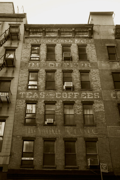 The remnants of a building sign,advertising coffees and teas.