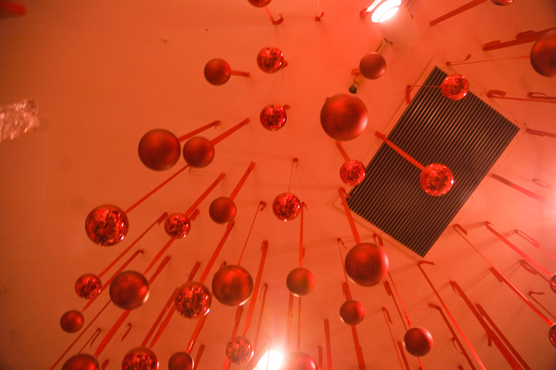 Red Christmas balls, suspended from a ceiling.