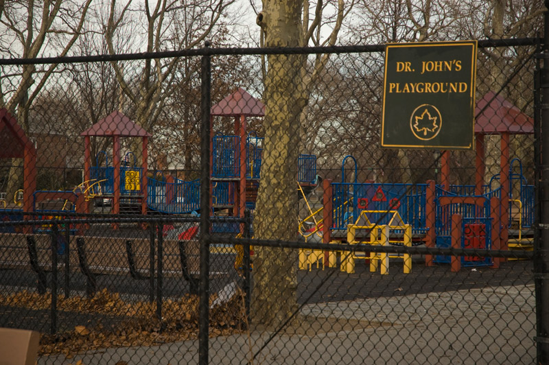 A playground, with a sign on the fence identifying it the honoree as Dr. John.