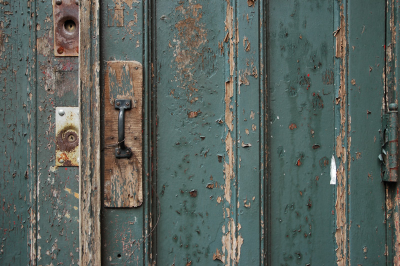 Peeling paint on wooden doors of a church.