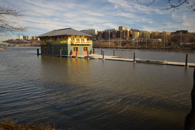 A colorful boat house in the middle of a river.