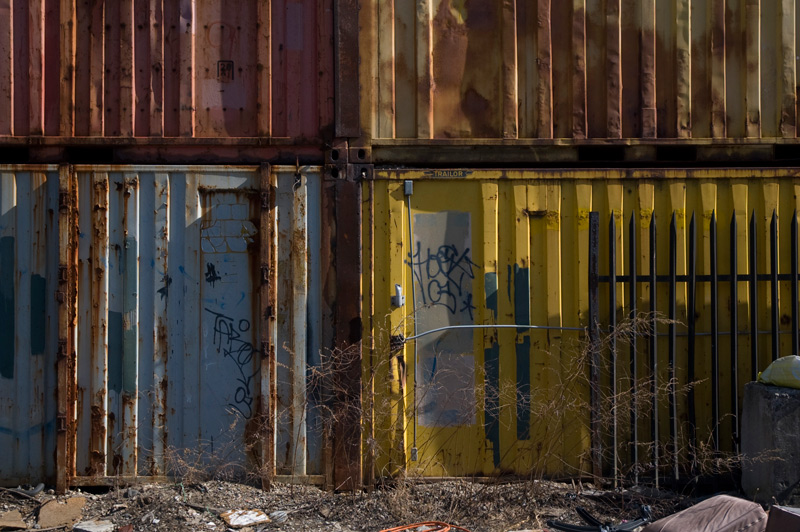 A metal wall made of the sides of corrugated metal shipping containers.