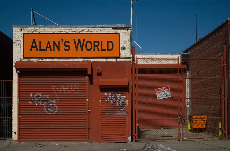 A small garage, with a large sign declaring it to be Alans World.