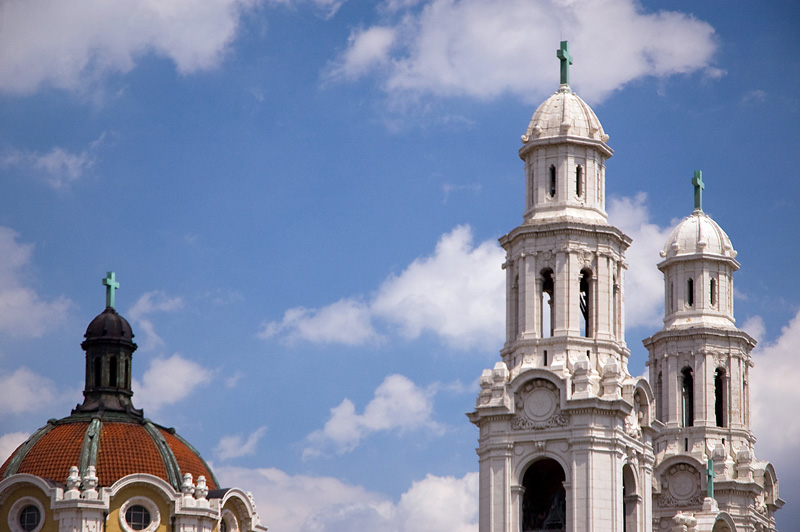 Three italianate church spires beneath a blue sky.