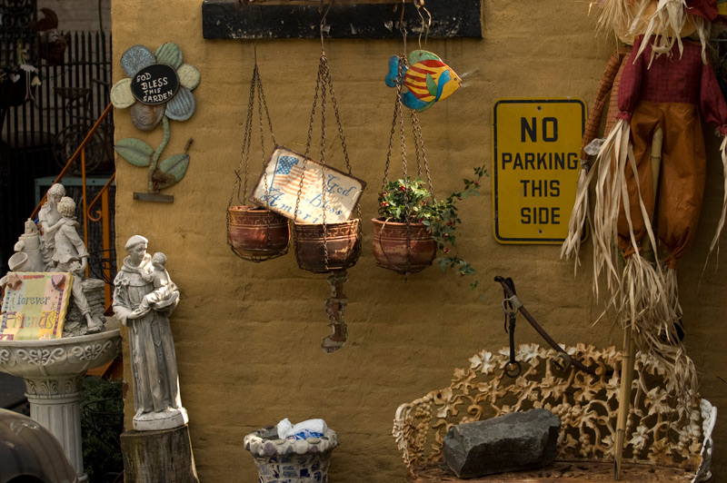 Potted plants, statuettes, and mottos hung on a wall.