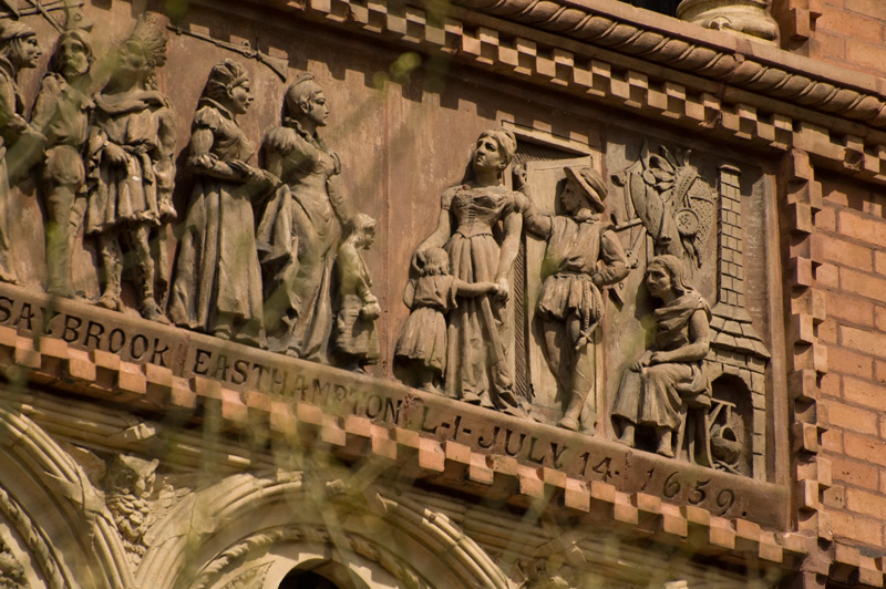 Colonial settlers and native Americans mingle on a panel on a building.