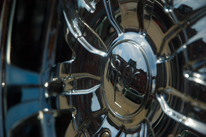 A street scene reflected in a hubcap.