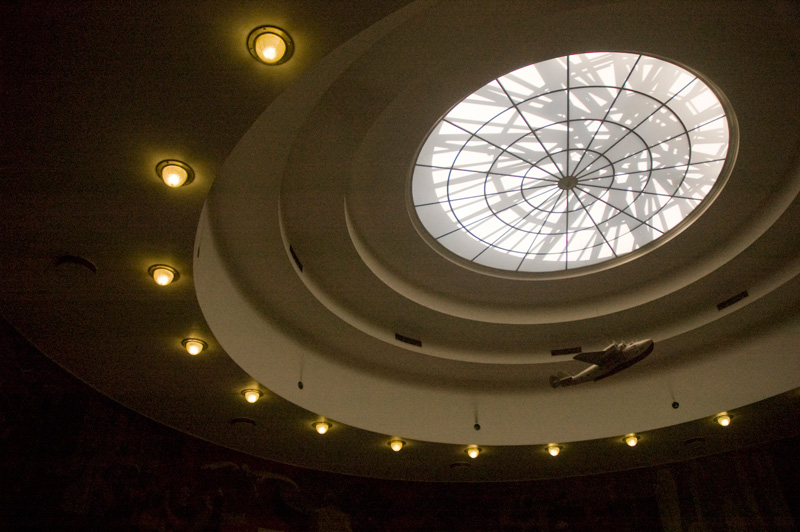 A circular window in a dome, with a model plane hung below the center.