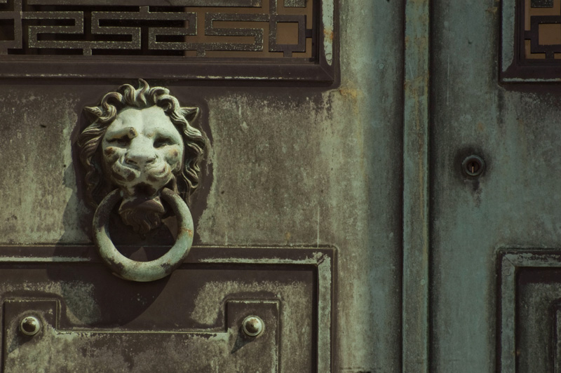 A door handle on a mausoleum, shaped as a lion head .