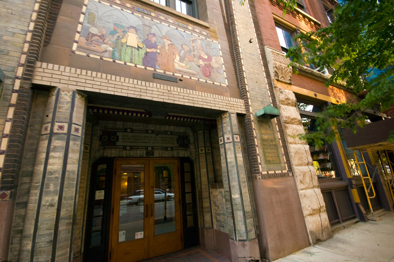 A mosaic showing printers, over a building entrance.