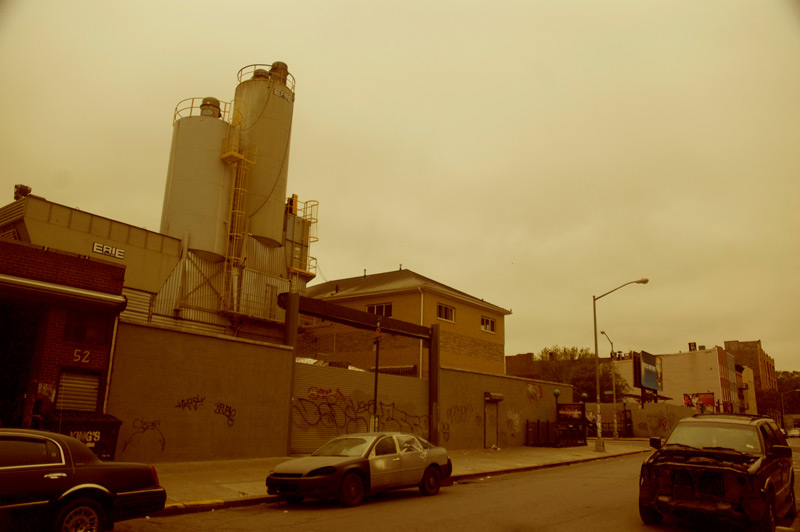 A barren street dominated by a cement factory.