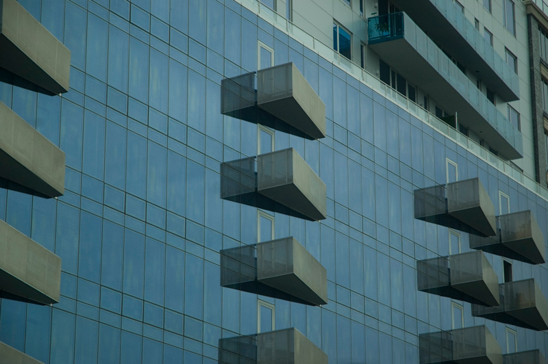 Triangular balconies on a glass-sided building.