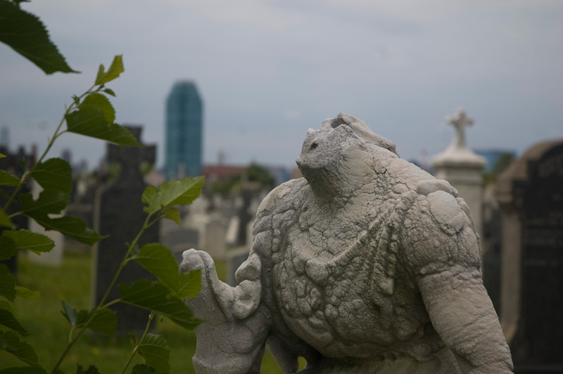 A headless statue in a cemetery.