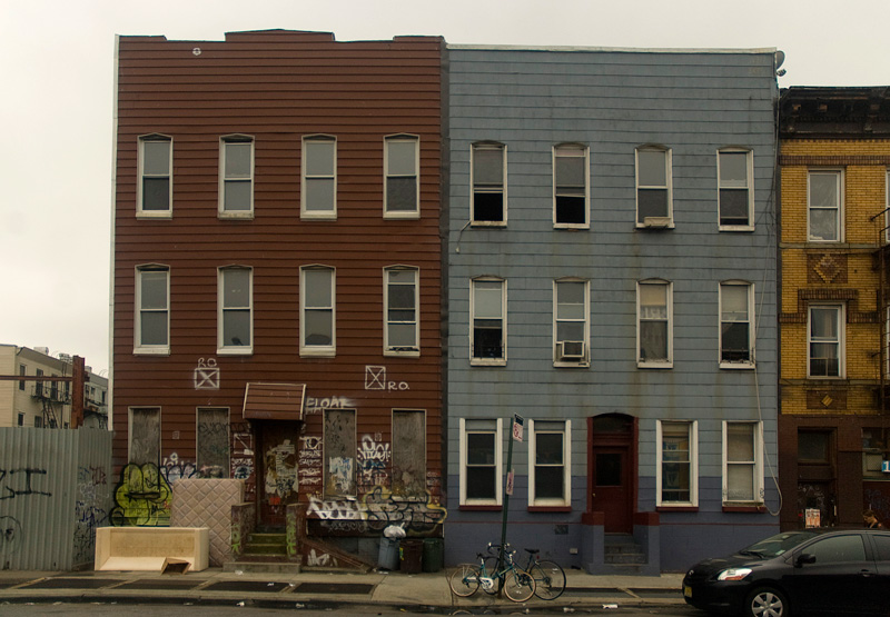 Two three story houses, in different states of disrepair.