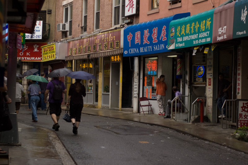 People in the rain on a bending street.