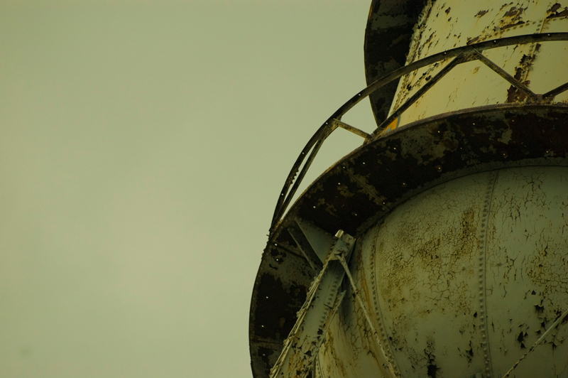 The curved underside of a rusting water tank.