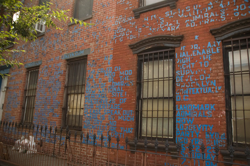A protest against development, in blue tape on a red brick house.
