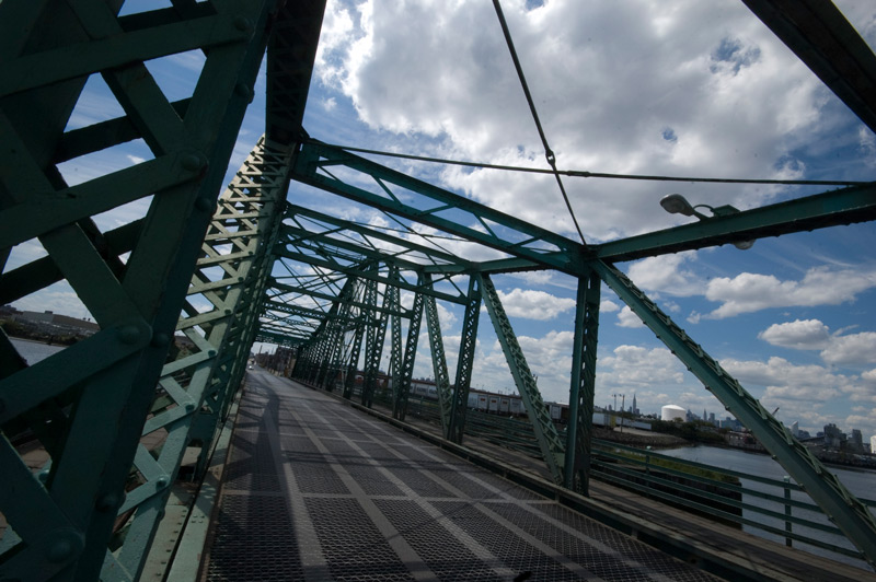 A steel trestle bridge over a small body of water.