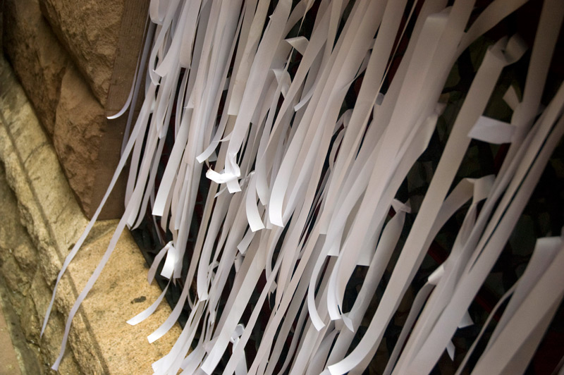 Slender white ribbons draping down on a window.