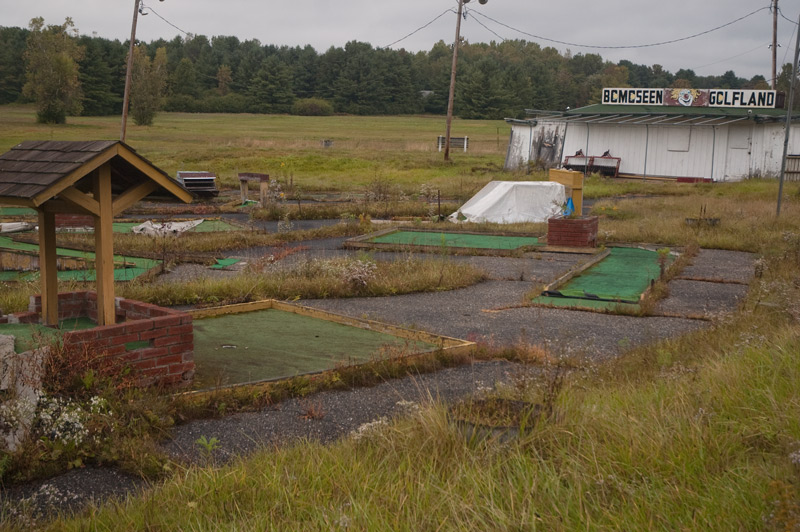 weeds cover an abandoned miniature golfcourse.