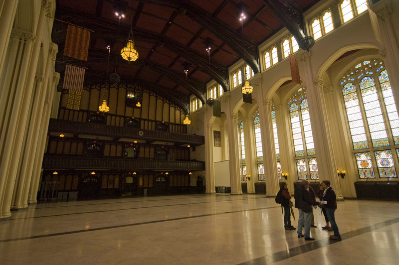 A hall with large, arched stained-gass windows