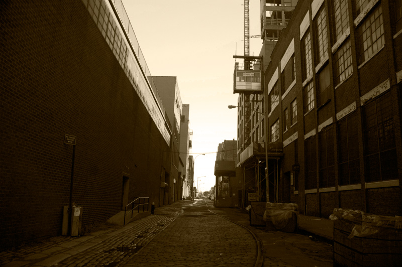 A narrow cobble-stone street with old rail tracks.