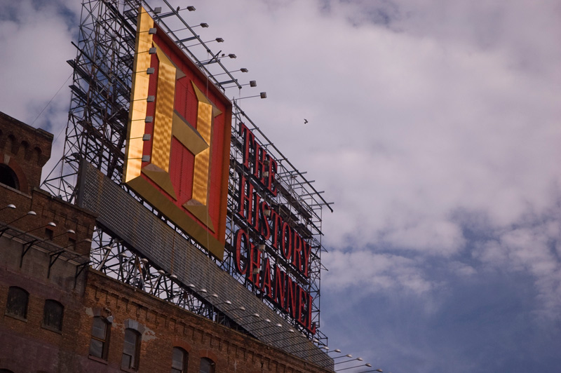 A bird flying towards a sign for the History Channel.