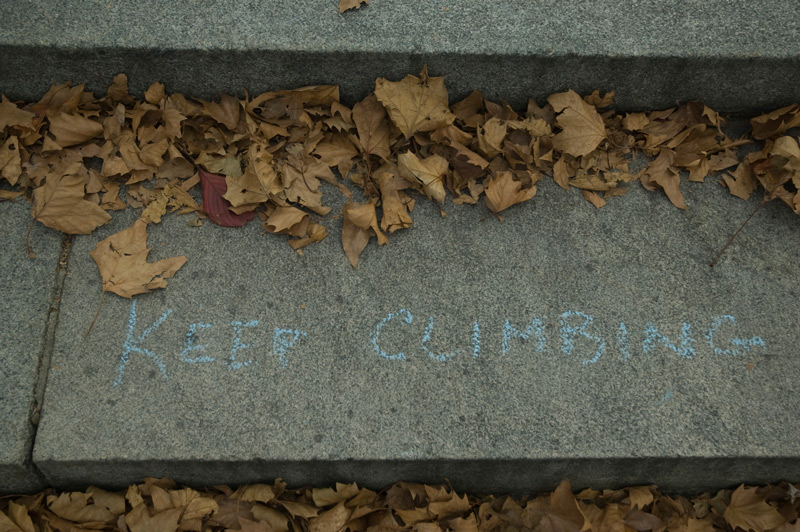 The words 'Keep Climbin,' written in chalk on steps.