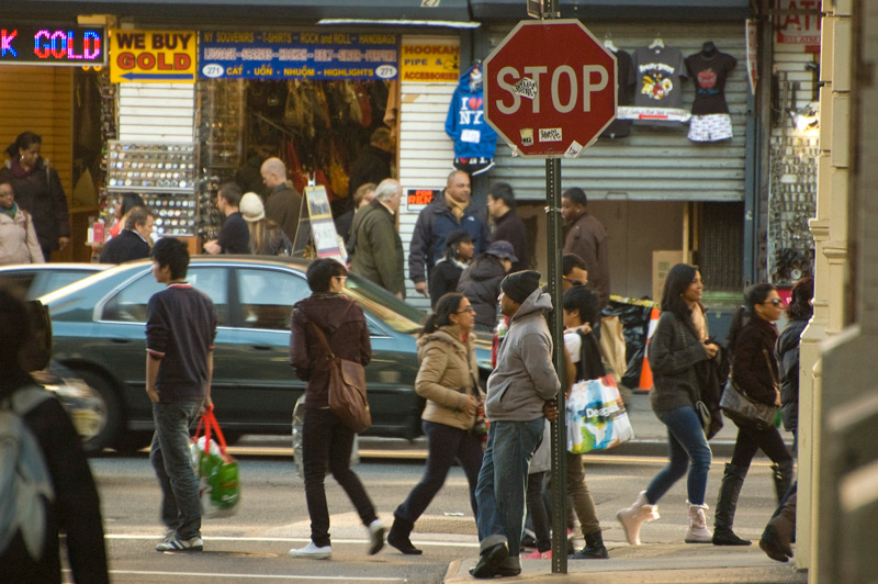 A man watches people walk rapidly by.