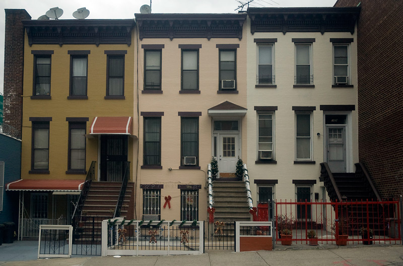 Three rowhouses, one decorated for Christmas.