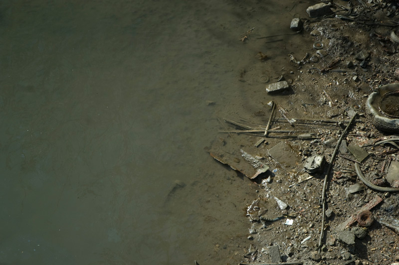 Pipes, old tires, and other debris revealed by low tide.