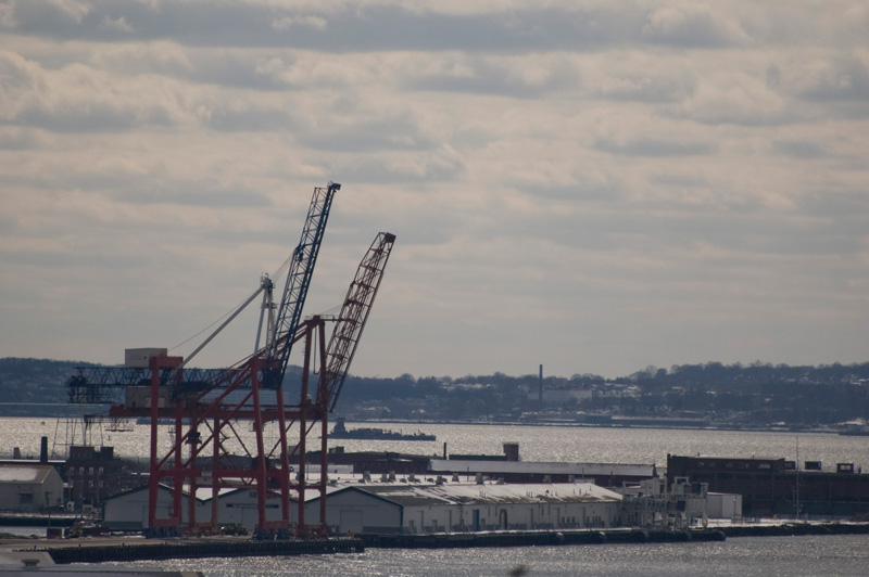 Two shipping cranes tower over their pier.