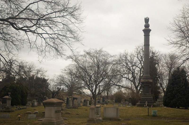 A tall column in a cemetery, topped by an eagle.