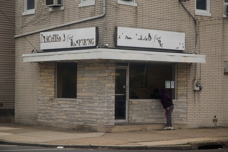 An empty corner store with signs in bad shape.