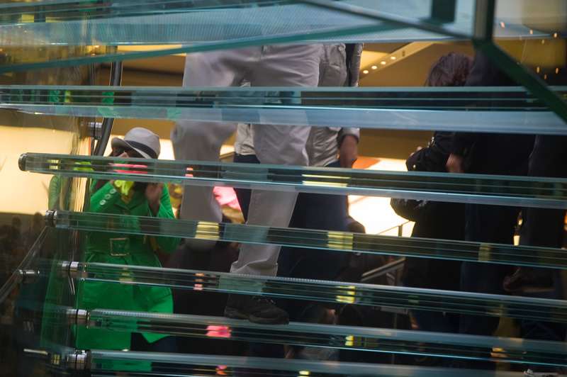 People ascending a clear, see-through staircase.