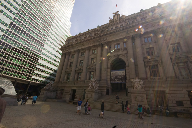 People on a plaza in front of an ornate building.