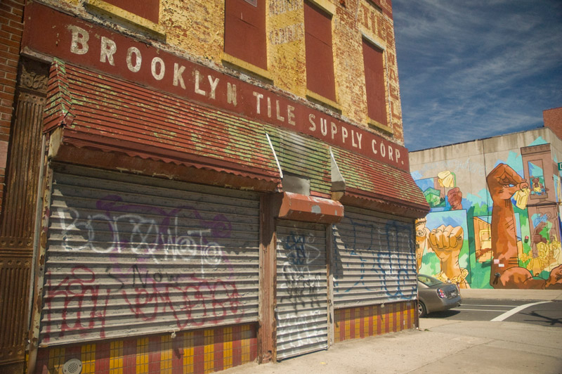 A once colorful brick building with peeling paint.