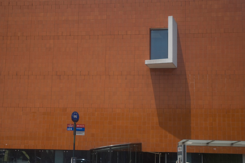 A white, L-shaped structure wrapped below a window and jutting from a wall