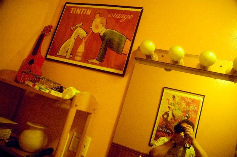 A bathroom with yellow walls and red accents.