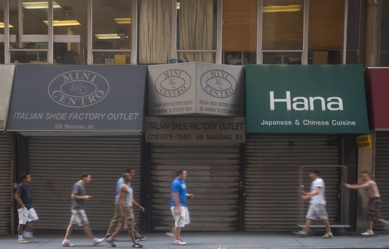 People walking past closed storefronts.