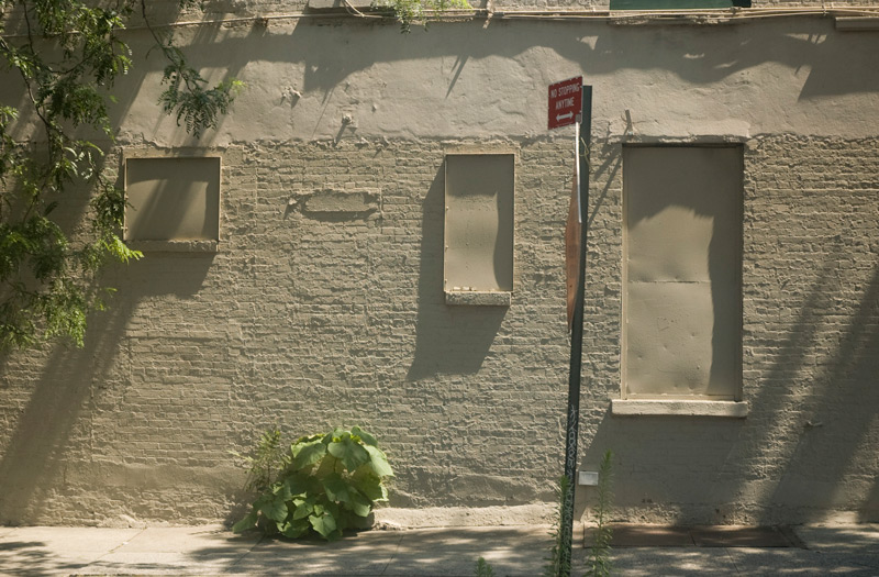 A textured wall, with closed-up windows.