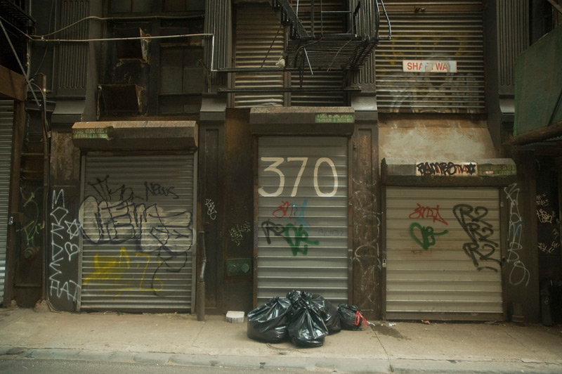 Rolled down shutters in an alley.