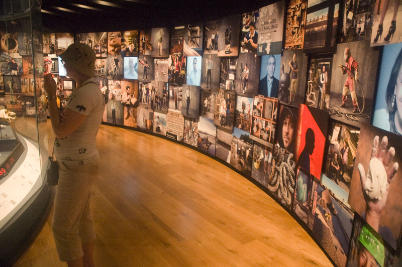 A museum wall showing various artists, manufacturers, and business people.